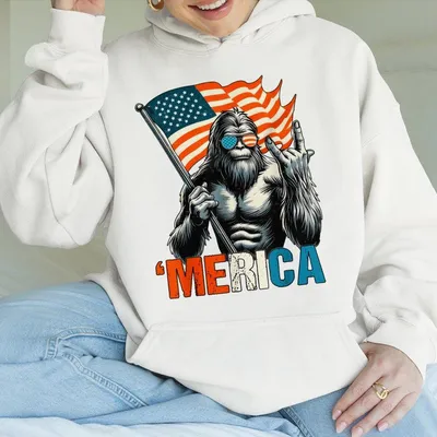 Bigfoot Merica Hoodie Funny Patriotic Hoodie Featuring Sasquatch Holding Flag Throwing A Hand Gesture Lighthear